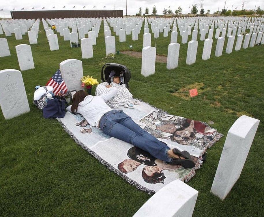 https://www.sandiegouniontribune.com/military/sdut-miramar-mourning-budenz-moody-brown-memorialday-2014may23-story.html?fbclid=IwAR24WkW-xhahhh4lUN281dR_pHKenoziLzUPW4QJIl4M7_0oKpgcQbzQeag
Jenn Budenz lies on a blanket with her 2-month-old son AJ as they visit the grave of her husband and father of her child Marine Major Andrew Budenz at the Miramar National Cemetery in San Diego. (Hayne Palmour IV / UT San Diego)